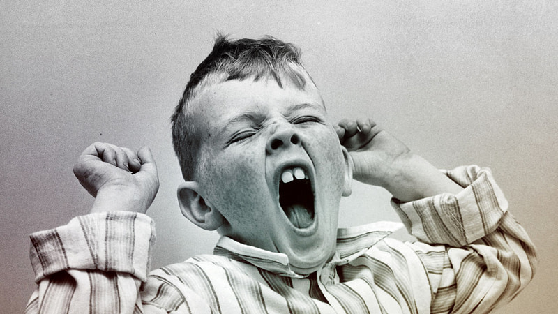 Boy yawning with hands up (black and white image)