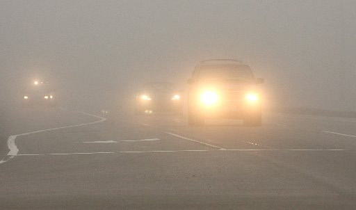 Cars with light on driving in Fog